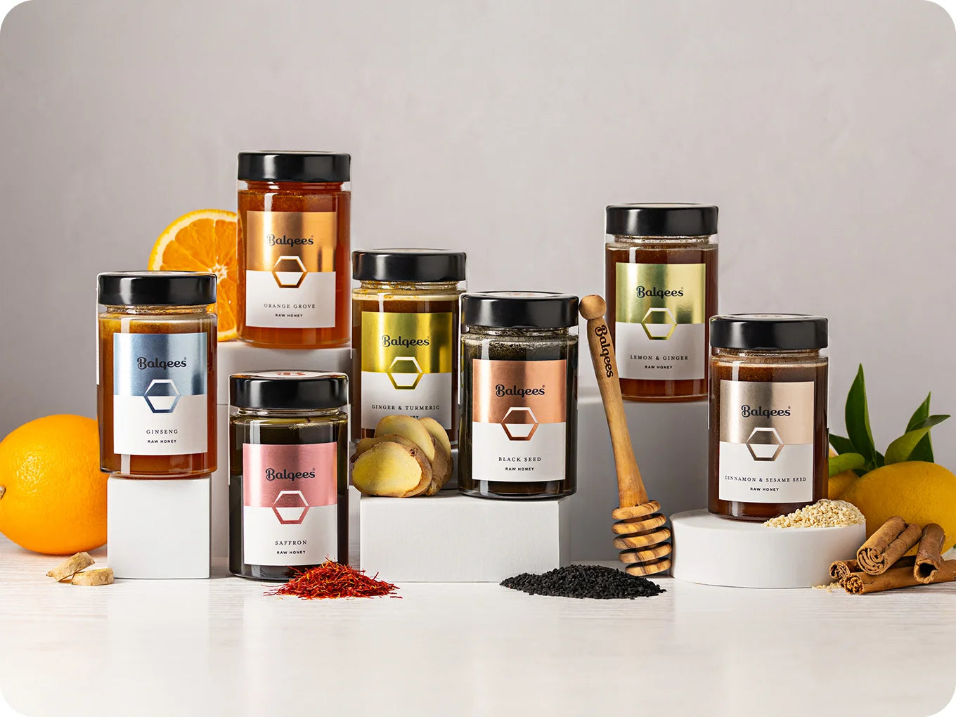 Collection of jars with labels on a white surface with fruits and spices.